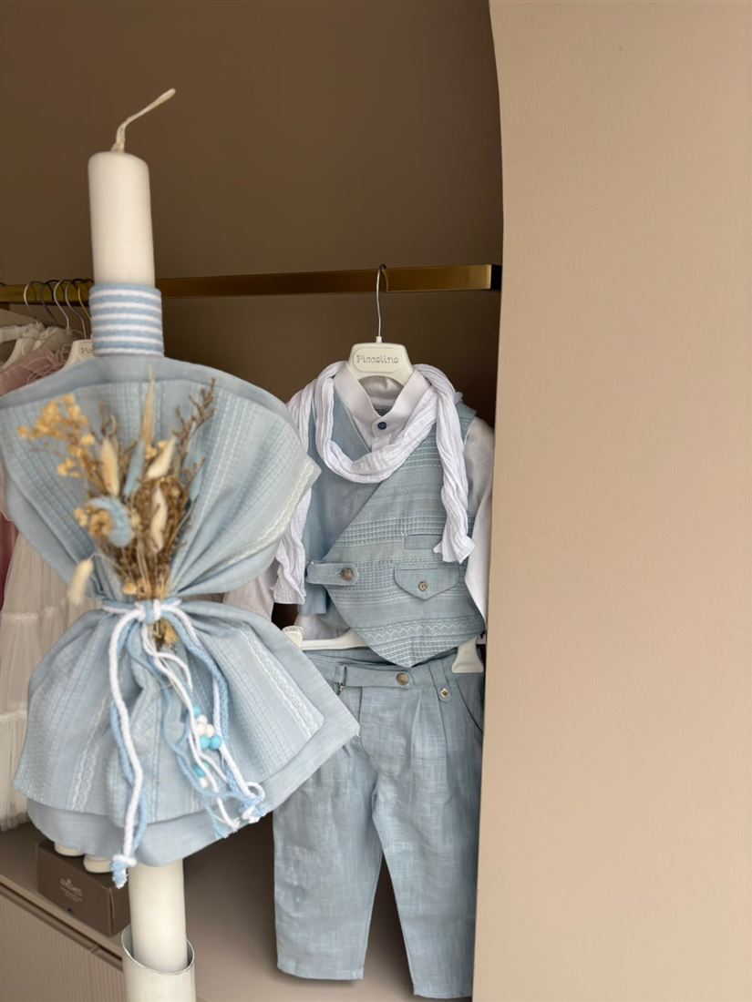 Hellblaues Jungs-Taufset in der Rundbogen-Nische des Ateliers: Weste mit Hemd auf Bügel und geschmückte Taufkerze